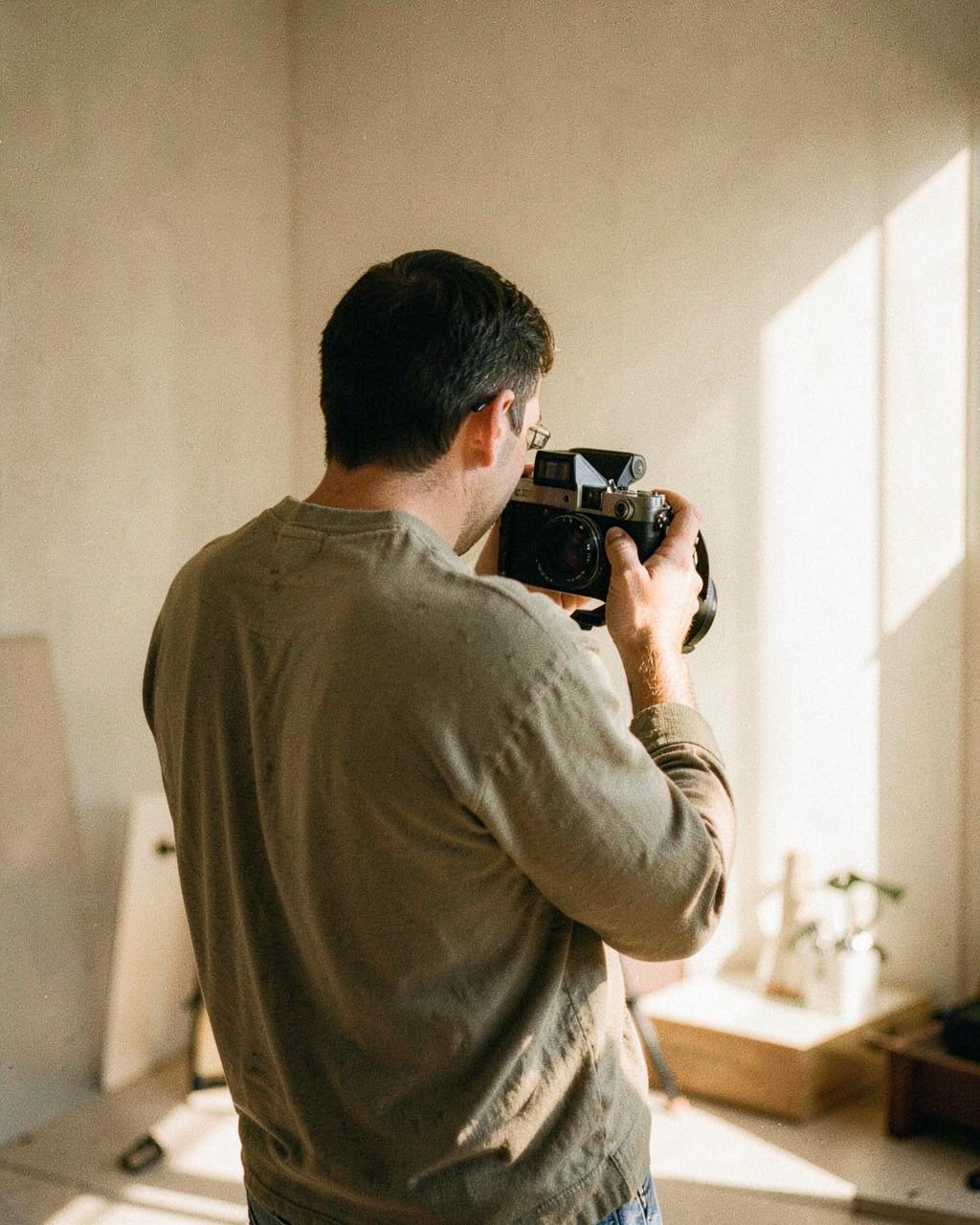 Nina at work with a film camera in a sunlit studio