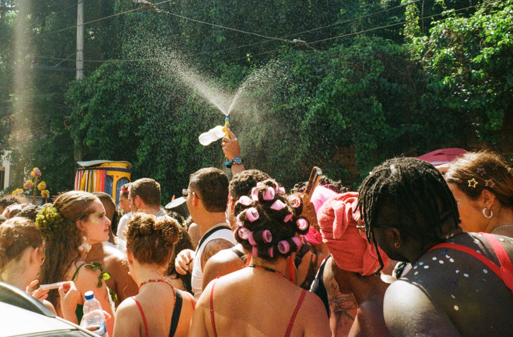 A water pistol spraying over a carnival crowd in the sunshine