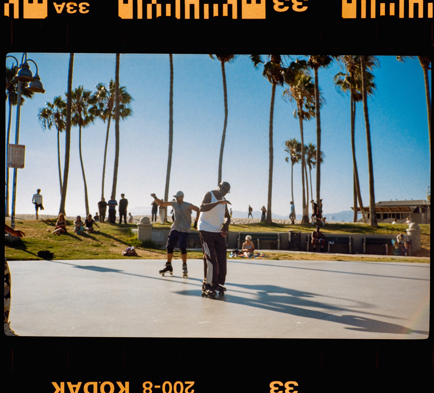 Roller skaters gliding across the open rink at Venice Beach