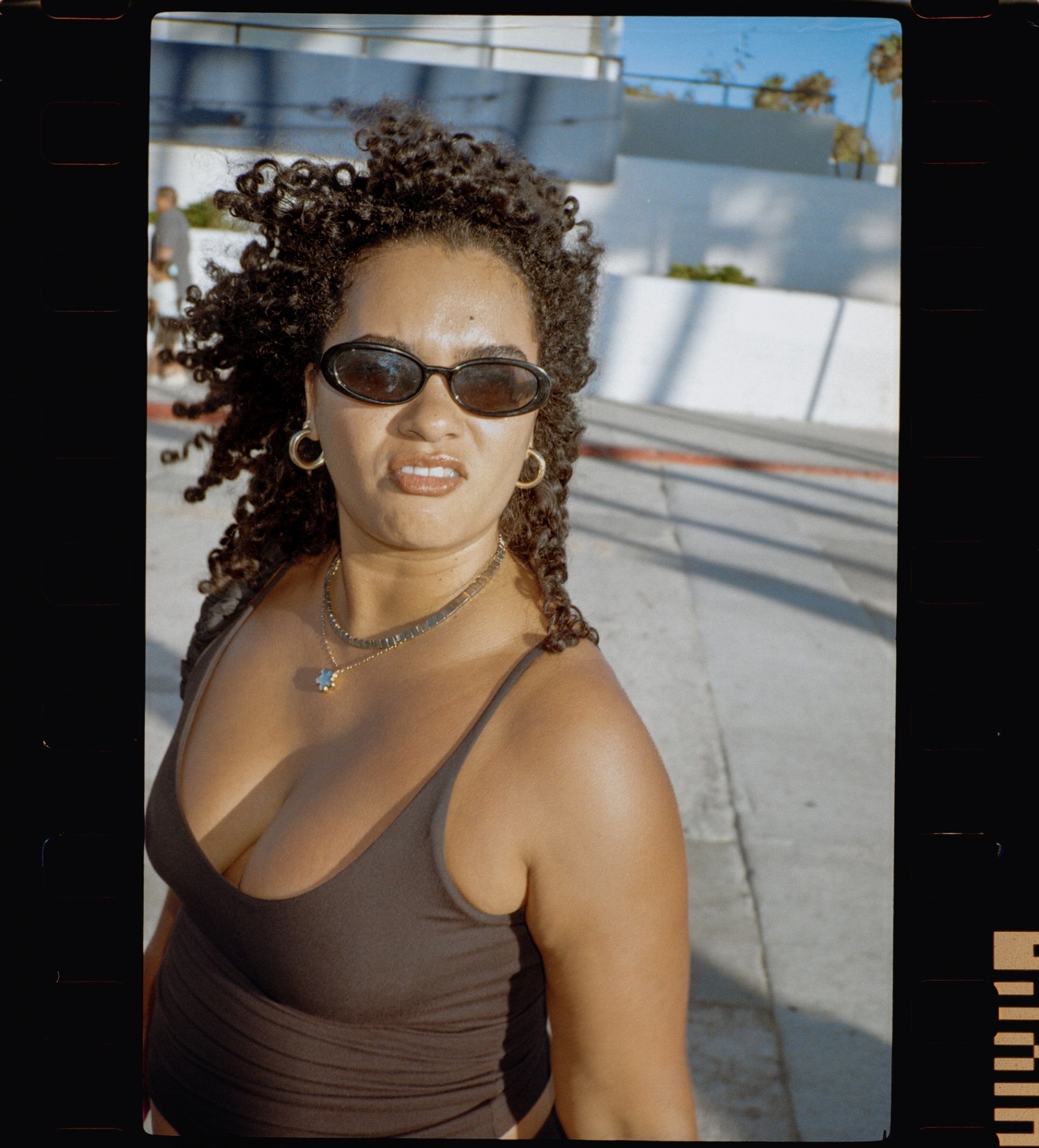 Woman with curly hair and oval sunglasses on the Venice boardwalk