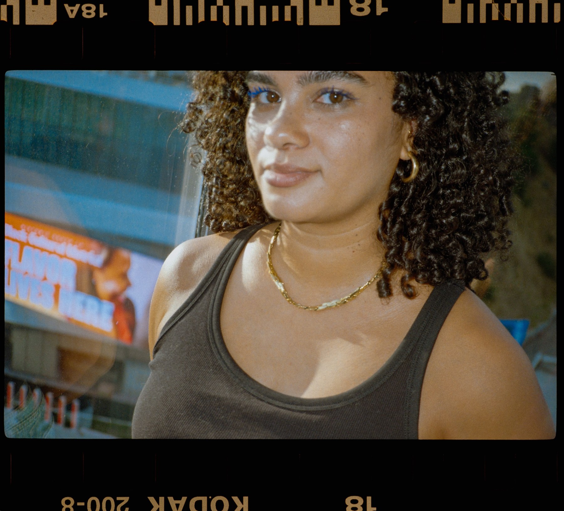 Woman with curly hair and a gold chain at a Venice food stand